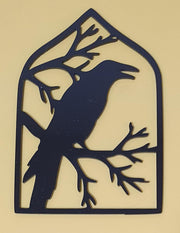 Black laser-cut acrylic Halloween decoration featuring a spooky raven perched among twisted tree branches inside a pointed gothic frame.