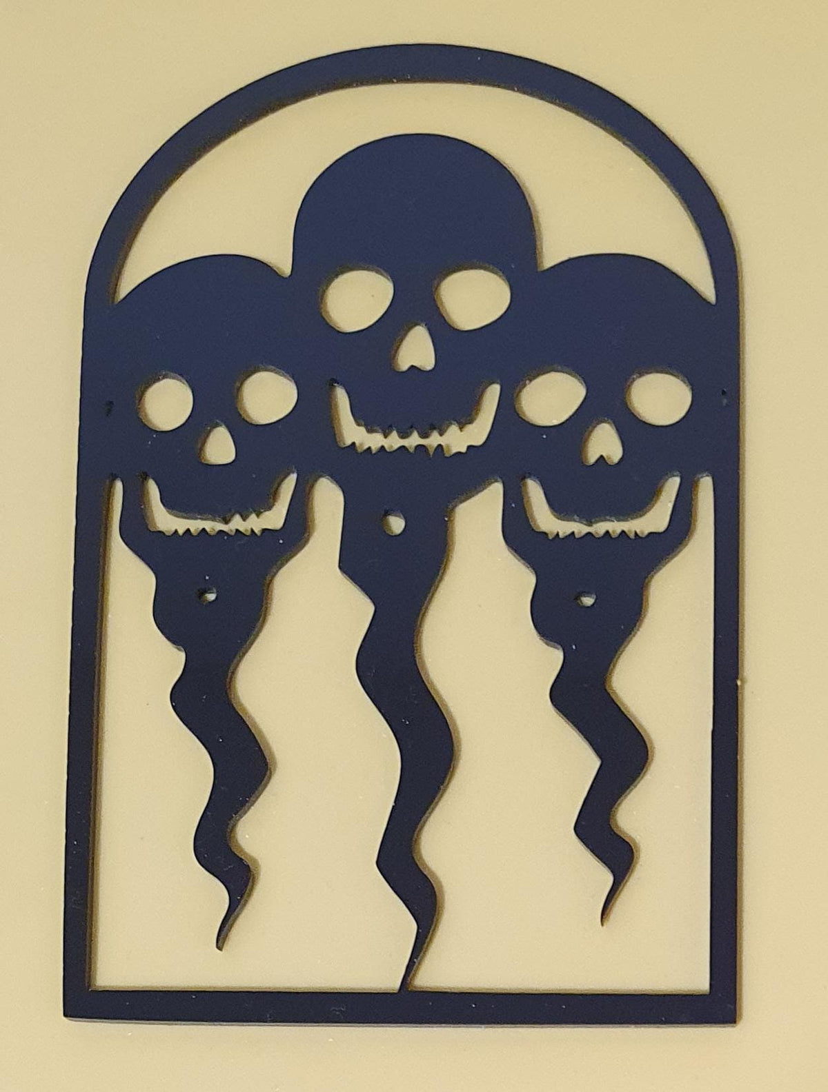 Black laser-cut acrylic Halloween decoration featuring three ghostly skeleton figures with skull faces inside a gothic arched frame.