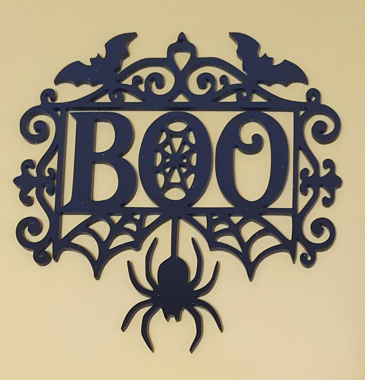 Black laser-cut acrylic BOO Halloween decoration featuring flying bats, spiderwebs, gothic flourishes and a large hanging spider.