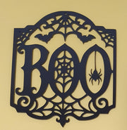 Black laser-cut acrylic BOO Halloween decoration featuring detailed spiderwebs, flying bats, a hanging spider and gothic curled flourishes.
