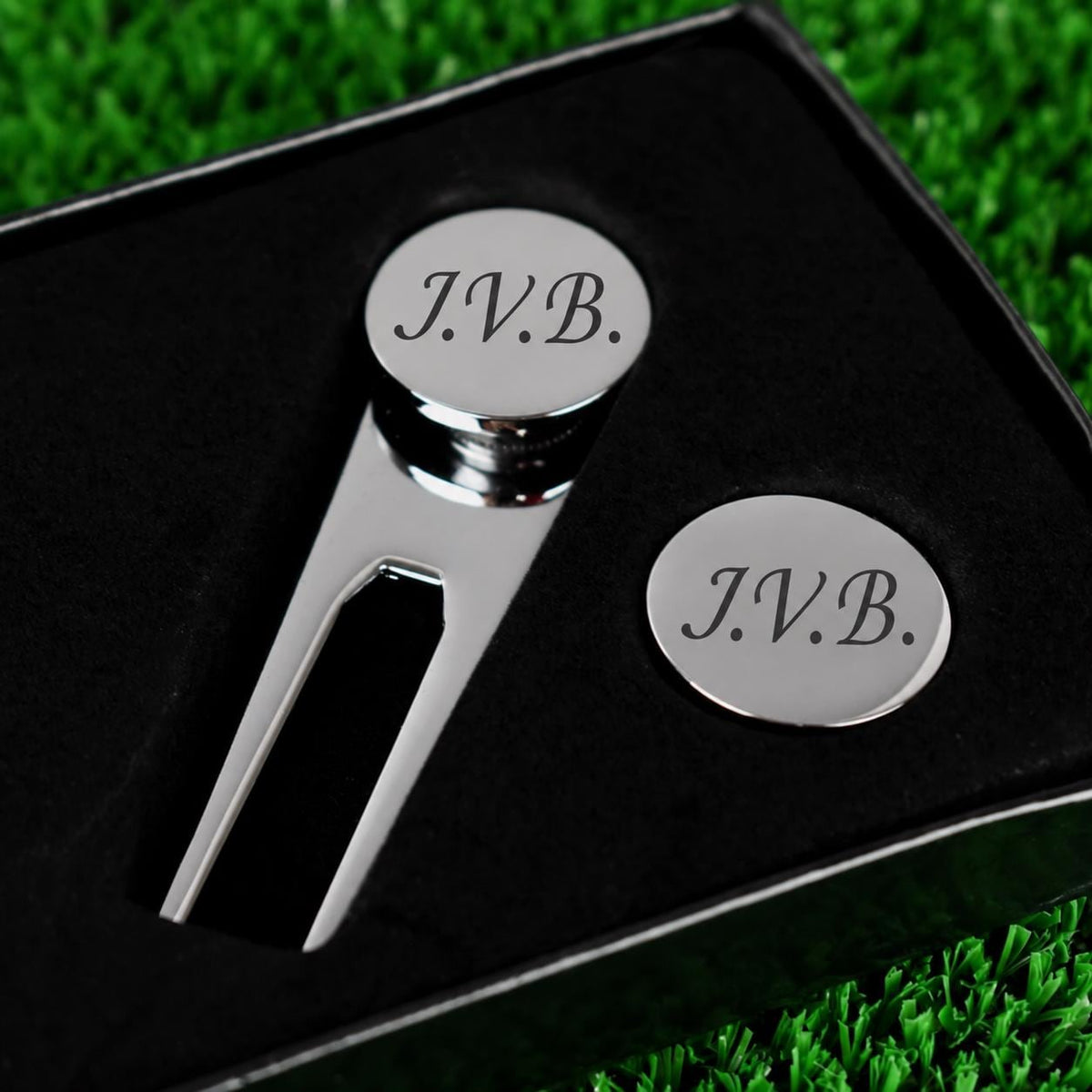 Close-up of initials personalised on the golf ball marker and pitch repairer set.