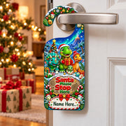 Personalised dinosaur Christmas door hanger showing three festive dinosaurs, presents and the words “Santa Please Stop Here”.