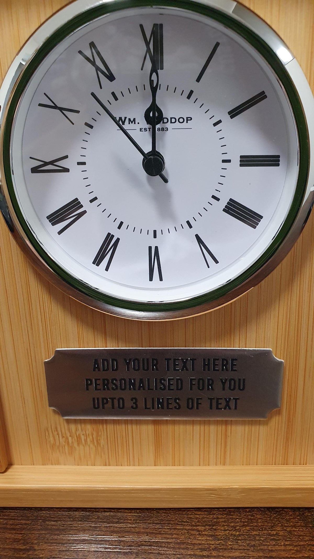 Detail view of the bamboo clock face and example three-line personalisation plaque.
