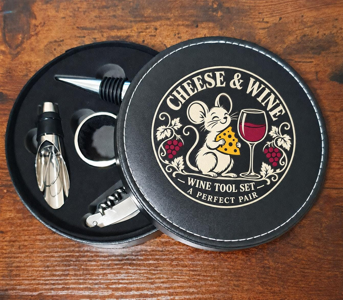 Open round wine tool case showing four accessories and the Cheese & Wine mouse design printed on the lid.