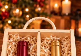 Close-up of the rope carry handle and upper compartments of a wooden double wine box, with wood wool surrounding two bottle necks.