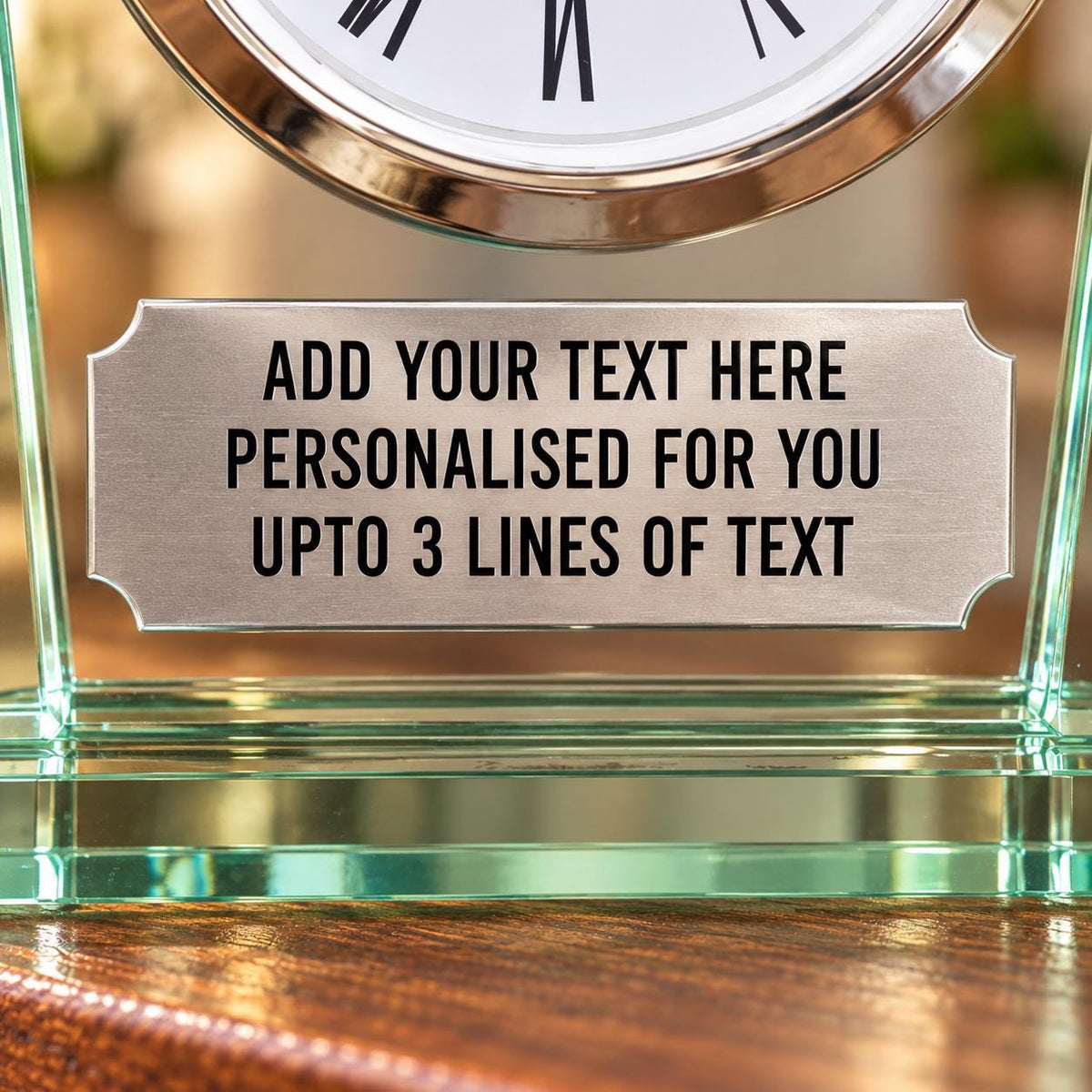 Close-up of the clock’s silver personalisation plaque, showing sample wording for a custom message of up to three lines.