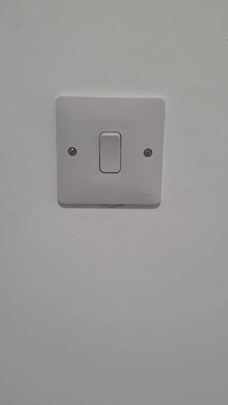 Colourful space-themed children's light switch surround featuring cute astronauts, rockets, smiling planets, aliens and stars surrounding a standard UK light switch.